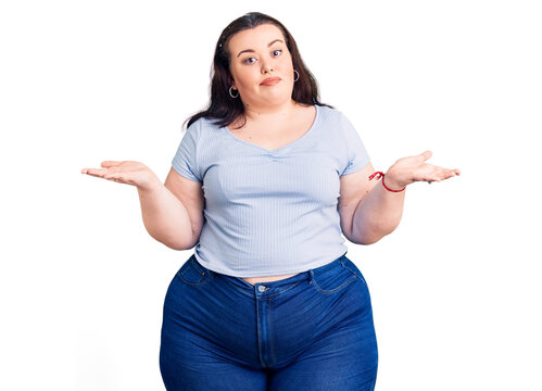 Young plus size woman wearing casual clothes clueless and confused expression with arms and hands raised. doubt concept.