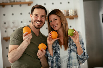 Young couple in kitchen. Happy couple is making a fruit salad..