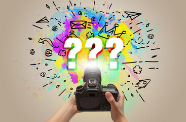 Close-up of a hand holding digital camera with abstract drawing and ??? inscription