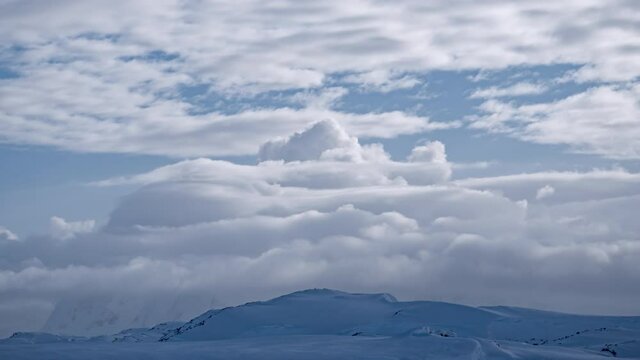 White clouds over mountain range timelapse aerial. Antarctica desert landscape of polar natural beauty. Epic nature scenery of arctic winter at cloudy day. Environment preserve scene of global warming