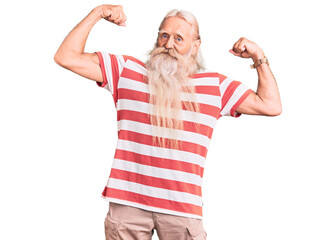 Old senior man with grey hair and long beard wearing striped tshirt showing arms muscles smiling proud. fitness concept.