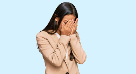Beautiful hispanic woman wearing business jacket with sad expression covering face with hands while crying. depression concept.