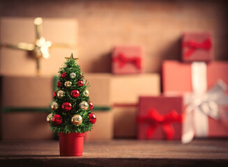Little Christmas tree and gift boxes on background