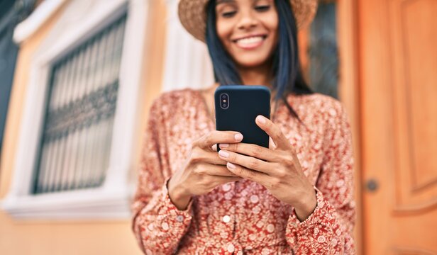 Young african american tourist woman on vacation smiling happy using smartphone at the city.
