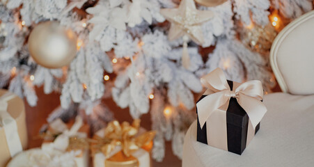 Christmas gift boxes near the Christmas tree on Christmas day. white decorations on the Christmas tree of Golden color