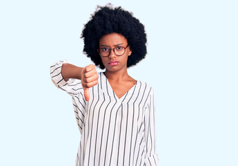 Fototapeta na wymiar Young african american woman wearing casual clothes and glasses looking unhappy and angry showing rejection and negative with thumbs down gesture. bad expression.