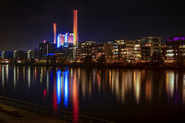 Westhafen in Frankfurt am Main bei Nacht vom südlichen Mainufer gesehen mit Wärmekraftwerk und Spieglungen im Wasser
