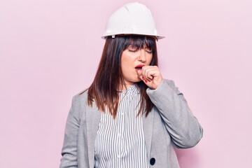 Young plus size woman wearing architect hardhat feeling unwell and coughing as symptom for cold or bronchitis. health care concept.