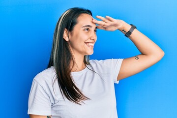 Young hispanic woman wearing casual white t shirt pointing fingers to camera with happy and funny face. good energy and vibes.