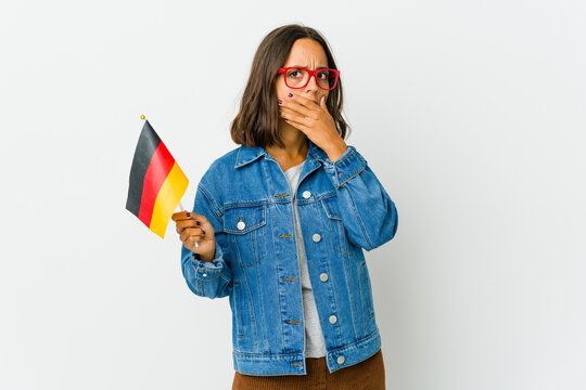 Young latin woman holding a german flag isolated on white background