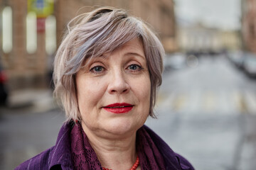 Beautiful aged woman's with short hair portrait outdoors.