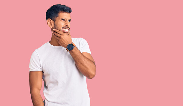 Young latin man wearing casual clothes thinking worried about a question, concerned and nervous with hand on chin