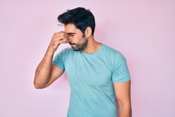 Handsome hispanic man with beard wearing casual clothes tired rubbing nose and eyes feeling fatigue and headache. stress and frustration concept.