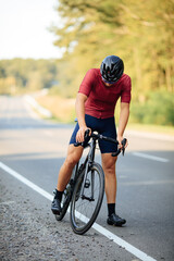 Cyclist with muscular legs preparing for morning ride