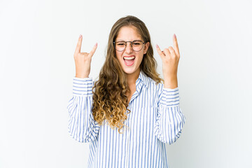 Young caucasian woman showing a horns gesture as a revolution concept.