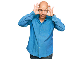 Fototapeta premium Middle age bald man wearing casual clothes trying to open eyes with fingers, sleepy and tired for morning fatigue