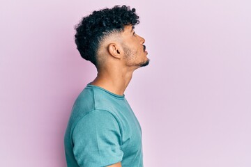 Obraz premium Young arab handsome man wearing casual clothes looking to side, relax profile pose with natural face with confident smile.