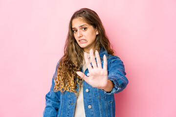 Young caucasian woman rejecting someone showing a gesture of disgust.