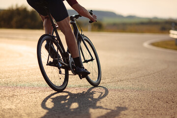 Close up of road cyclist with strong legs biking outdoor