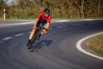 Muscular guy enjoying sport activity on black bike