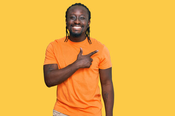 Handsome young african american man wearing casual clothes cheerful with a smile of face pointing with hand and finger up to the side with happy and natural expression on face