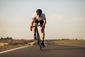 Fototapeta Happy road cyclist in protective helmet training outdoors obraz