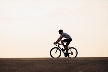 Fototapeta na wymiar Side view of man in sport clothing riding on road