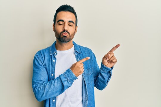 Young hispanic man with beard pointing with fingers to the side depressed and worry for distress, crying angry and afraid. sad expression.