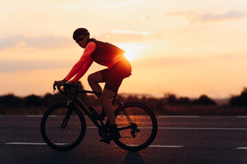 Fototapeta na wymiar Sporty man in activewear riding bike on road
