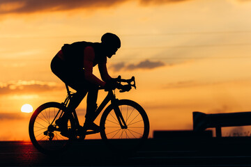 Muscular guy in cycling clothing biking on fresh air