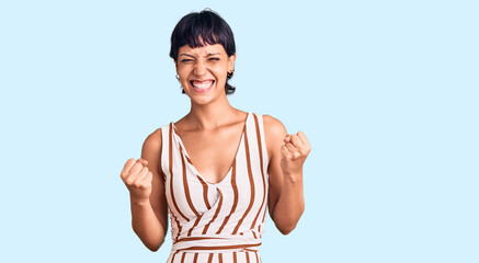 Young brunette woman with short hair wearing summer outfit excited for success with arms raised and eyes closed celebrating victory smiling. winner concept. © Krakenimages.com