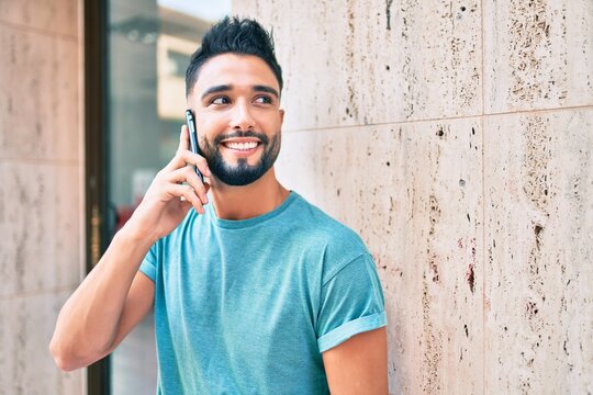 Young arab man with serious expression talking on the smartphone at the city.