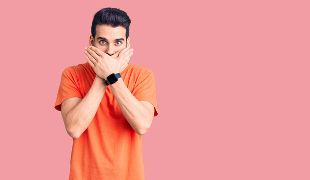 Young handsome man with beard wearing casual t-shirt shocked covering mouth with hands for mistake. secret concept.