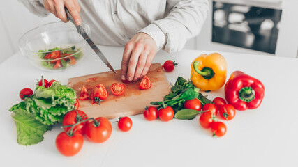 Men preparing salad in white kitchen. Cooking homemade food.