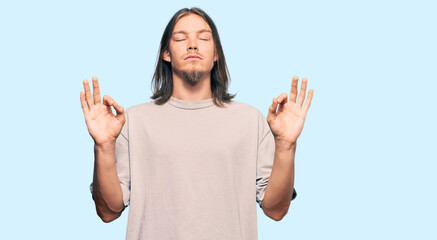 Handsome caucasian man with long hair wearing casual clothes relax and smiling with eyes closed doing meditation gesture with fingers. yoga concept.