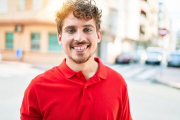 Young handsome caucasian man smiling happy walking at city.