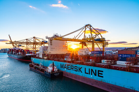 Barcelona, Spain - November 06 2018: Maersk Line Freighter Ship, Yang Ming YM Cargo Container Vessel, Spabunker Treinta bunkering tanker at Port/ Pier. Cranes load/ unload bulk merchant containers. 