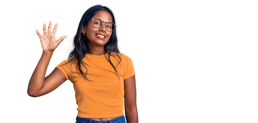 Young indian girl wearing casual clothes and glasses showing and pointing up with fingers number...