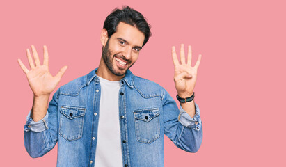 Young hispanic man wearing casual clothes showing and pointing up with fingers number nine while...
