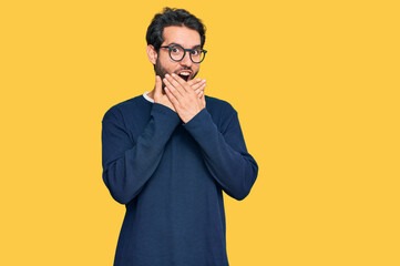 Young hispanic man wearing casual clothes and glasses shocked covering mouth with hands for mistake. secret concept.