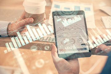 Double exposure of man's hands holding and using a phone and financial chart drawing. Market analysis concept.