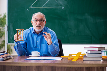 Old male math teacher in time management concept