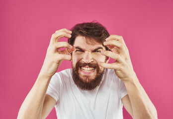 A man on a pink background gestures with his hands Copy Space irritability emotions