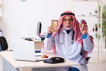 Old male arab doctor cardiologist working in the clinic