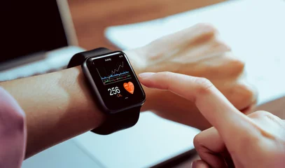 Fotobehang Close up of hand touching smartwatch with health app on the screen, gadget for fitness active lifestyle. © sitthiphong