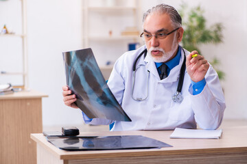 Old male doctor radiologist working in the hospital