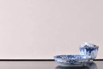 picture plate. with picture rice bowl. put on a Japanese lacquer shelf. This is a very fine example of Japanese traditional antique “ imari ware ”. blurred background soft focus image.