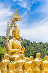 Row of disciple statues surrounding big buddha statue in public to the general public worship worship.