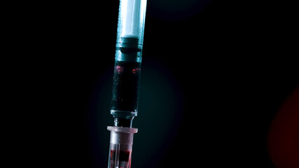 Blood is taken for tests with a medical syringe.