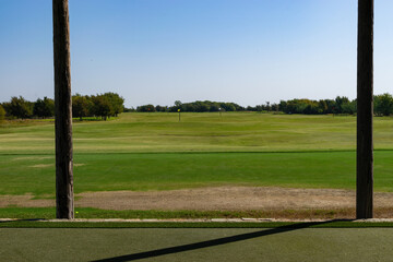 View from a golf driving range tee box flanked by two posts